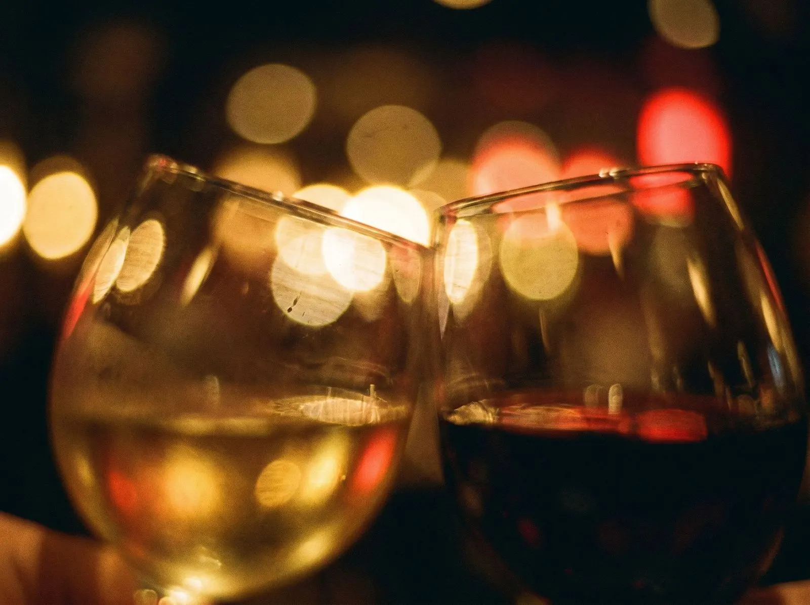 Warm bokeh and wine glasses, dim restaurant
